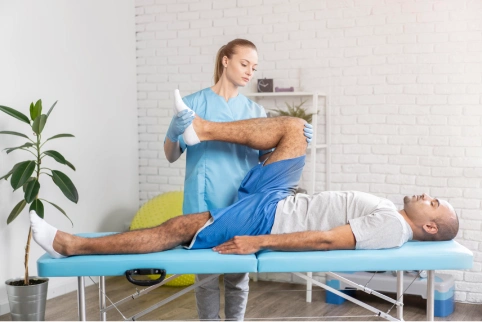female physiotherapist checking man leg